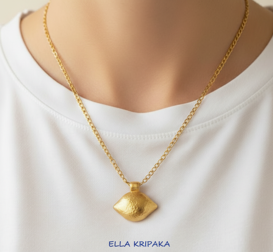 24k 9999 gold hammered Byzantine dome pendant with shiny forged gold textures is on chain wearing on person in a white t-shirt, artist's name 'Ella Kripaka'