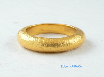 Hammered 24k 9999 Gold thick ring Ancient Rome style and with forged textured gold on a white paper surface, artist-jeweler's name 'Ella Kripaka' branding