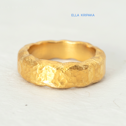 Organic hammered 24k 9999 gold wavy ring band and with forged gold textures on white paper surface, artist-jeweler's name 'Ella Kripaka' branding
