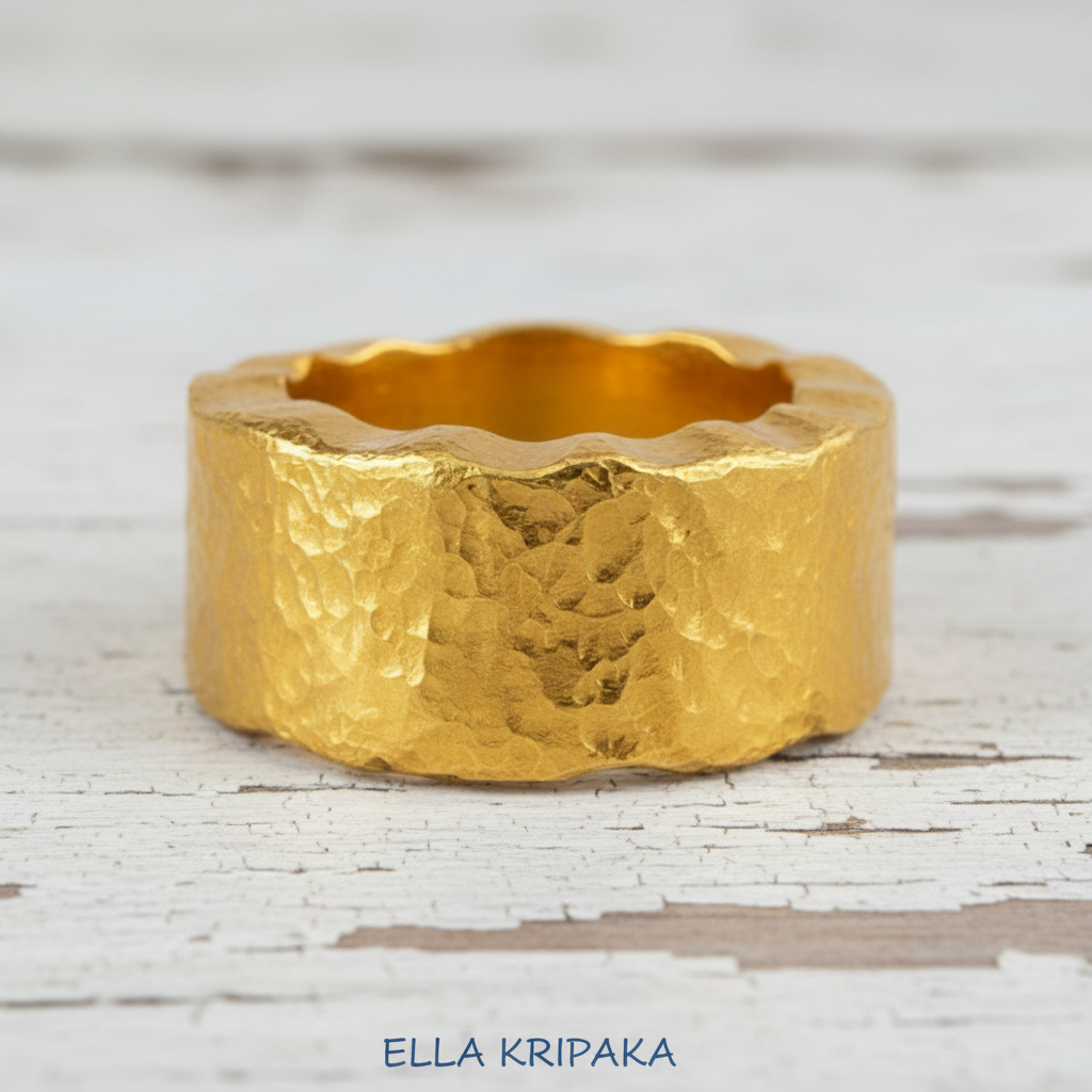 Organic hammered 24k 9999 Gold wavy ring band with thick wavy edges and with forged gold textures on white old wooden surface, artist-jeweler's name 'Ella Kripaka' branding