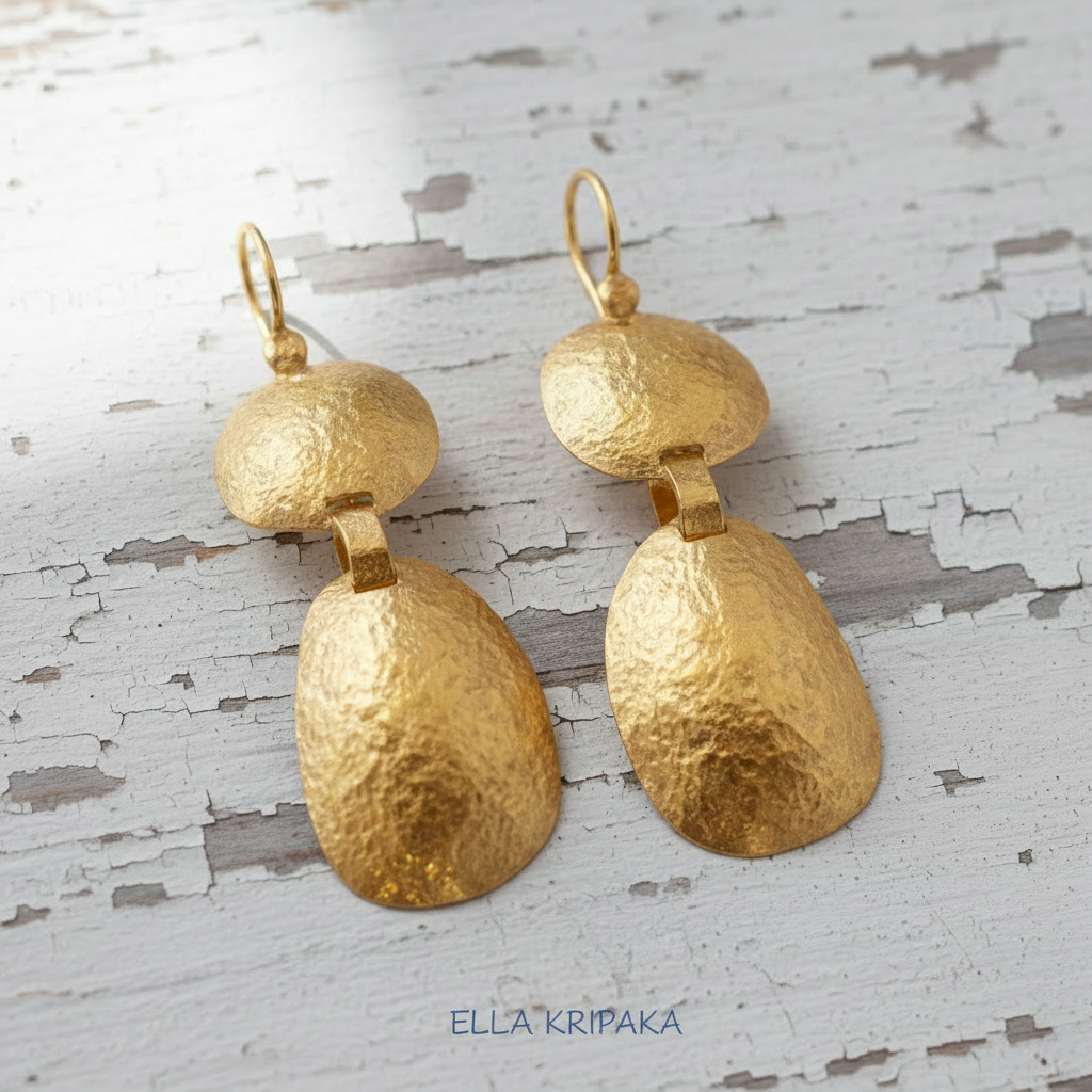 Uneven 24k 9999 gold hammered organic earrings with forged gold textures is on a white old wooden surface, artist's name 'Ella Kripaka'