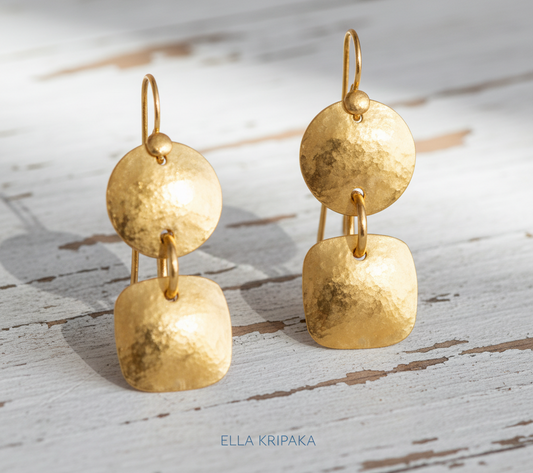 24k 9999 gold hammered Byzantine convex earrings with forged gold textures is on a old wooden surface, artist's name 'Ella Kripaka'