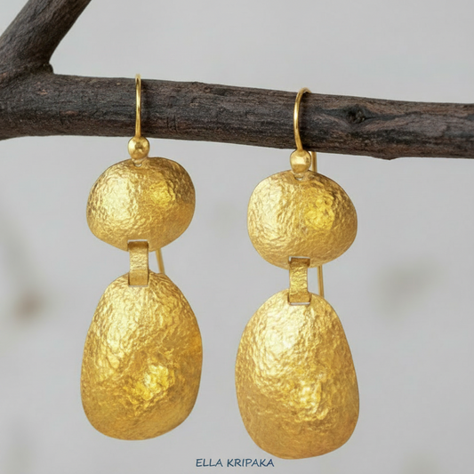 Organic 24k 9999 gold hammered uneven dome earrings with forged gold textures hanging on a branch, artist's name 'Ella Kripaka'