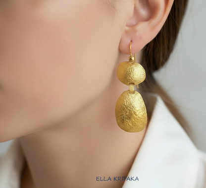 24k 9999 gold hammered convex organic earrings with forged gold textures is worn by person, artist's name 'Ella Kripaka'