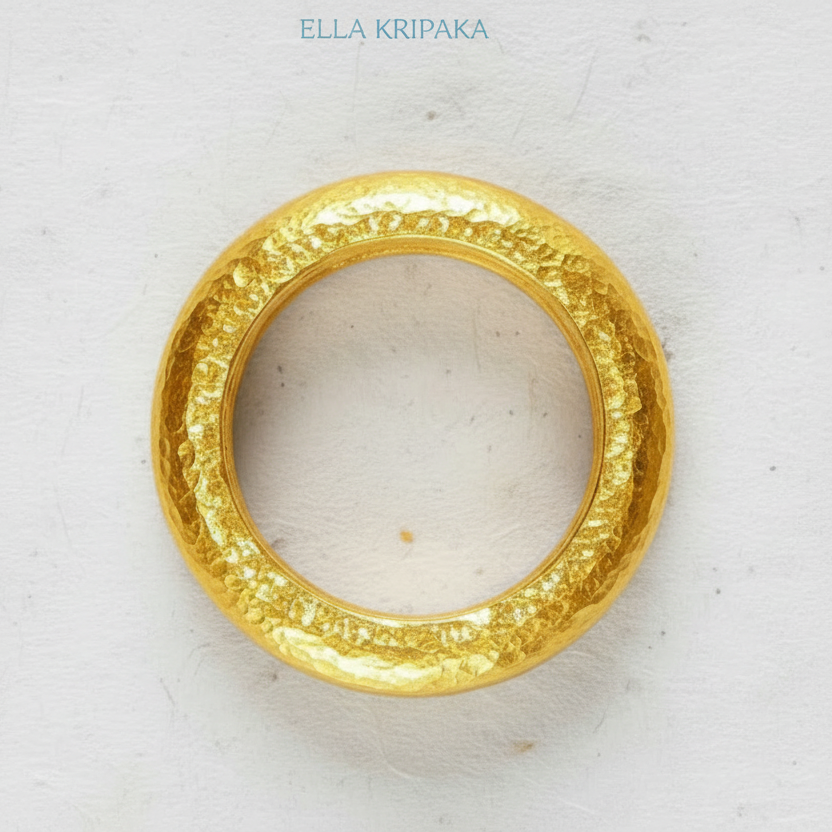 Hammered 24k 9999 Gold thick ring Ancient Rome style and with forged textured gold on a white paper surface, artist-jeweler's name 'Ella Kripaka' branding