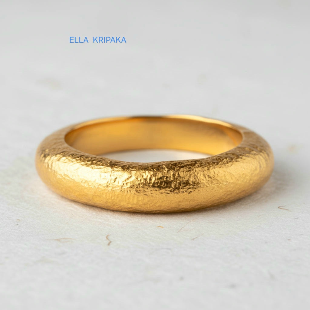 Hammered 24k 9999 Gold thick ring Ancient Rome style and with forged textured gold on a white paper surface, artist-jeweler's name 'Ella Kripaka' branding