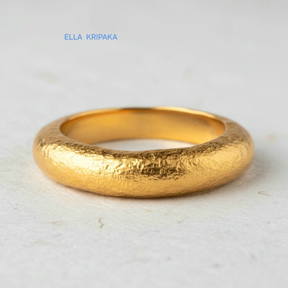 Hammered 24k 9999 Gold thick ring Ancient Rome style and with forged textured gold on a white paper surface, artist-jeweler's name 'Ella Kripaka' branding