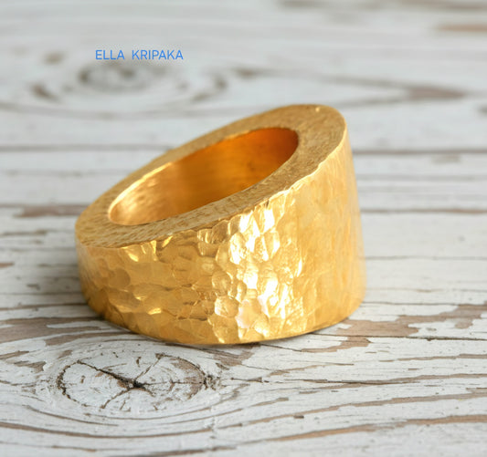 Hammered 24k 9999 Gold ring thick signet Ancient Rome style and with forged textured gold on a white old wooden surface, artist-jeweler's name 'Ella Kripaka' branding