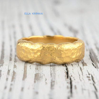 Organic hammered 24k 9999 gold wavy ring band and with forged gold textures on white old wooden surface, artist-jeweler's name 'Ella Kripaka' branding