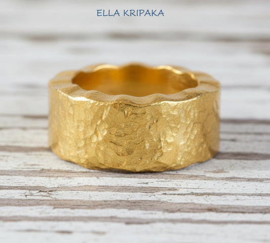 Organic hammered 24k 9999 Gold wavy ring band with thick wavy edges and with forged gold textures on white old wooden surface, artist-jeweler's name 'Ella Kripaka' branding