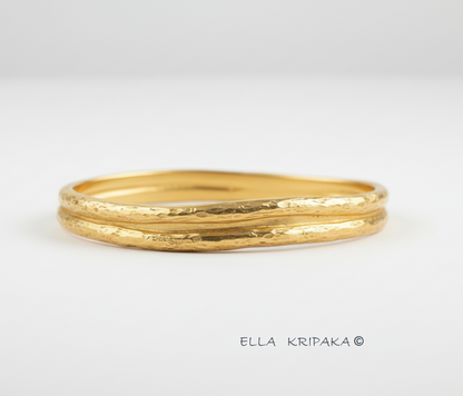 Organic 24k gold 9999 gold hammered bangle thick bracelet with uneven edges on a white background, name of artist-jeweler 'Ella Kripaka'