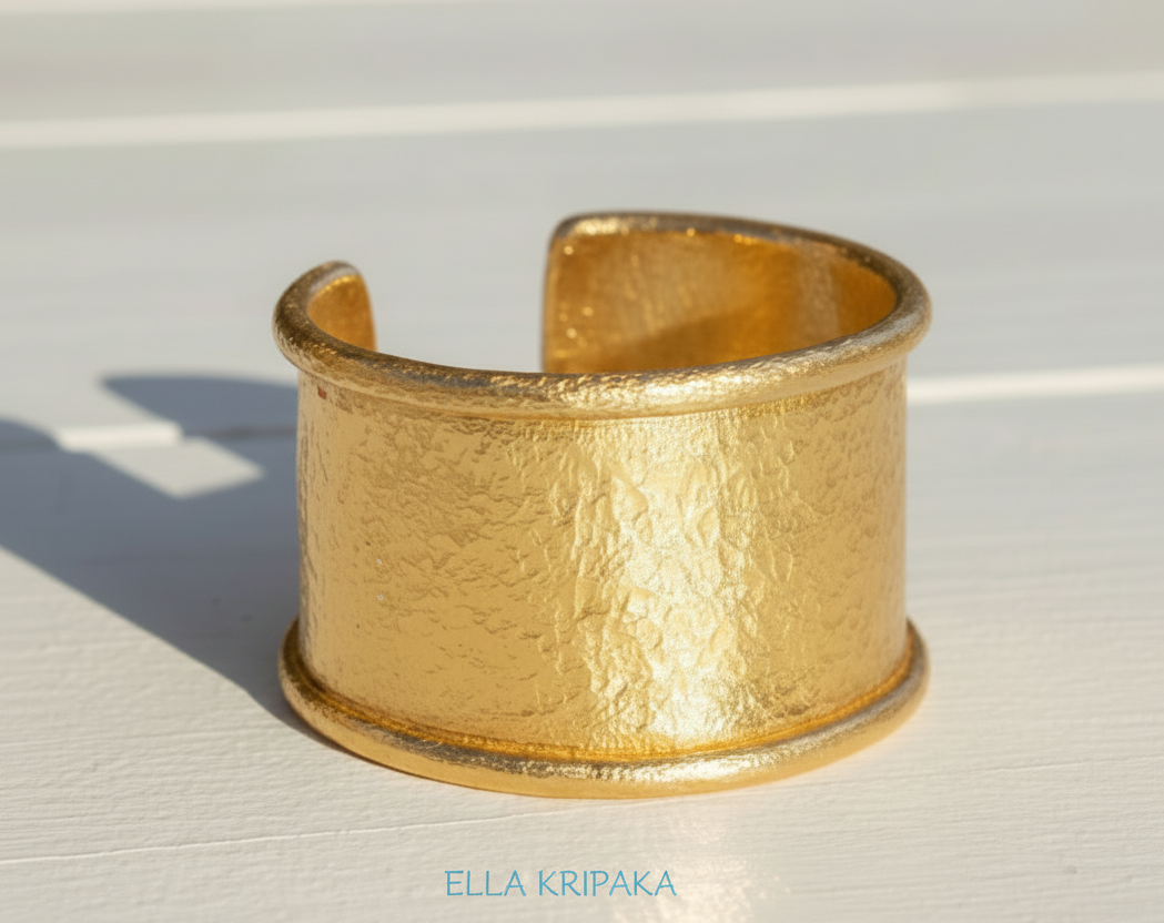 Hammered 24k 9999 gold bracelet large cuff Ancient Rome style with thick borders on a white background, branding artist-jeweler name 'Ella Kripaka'