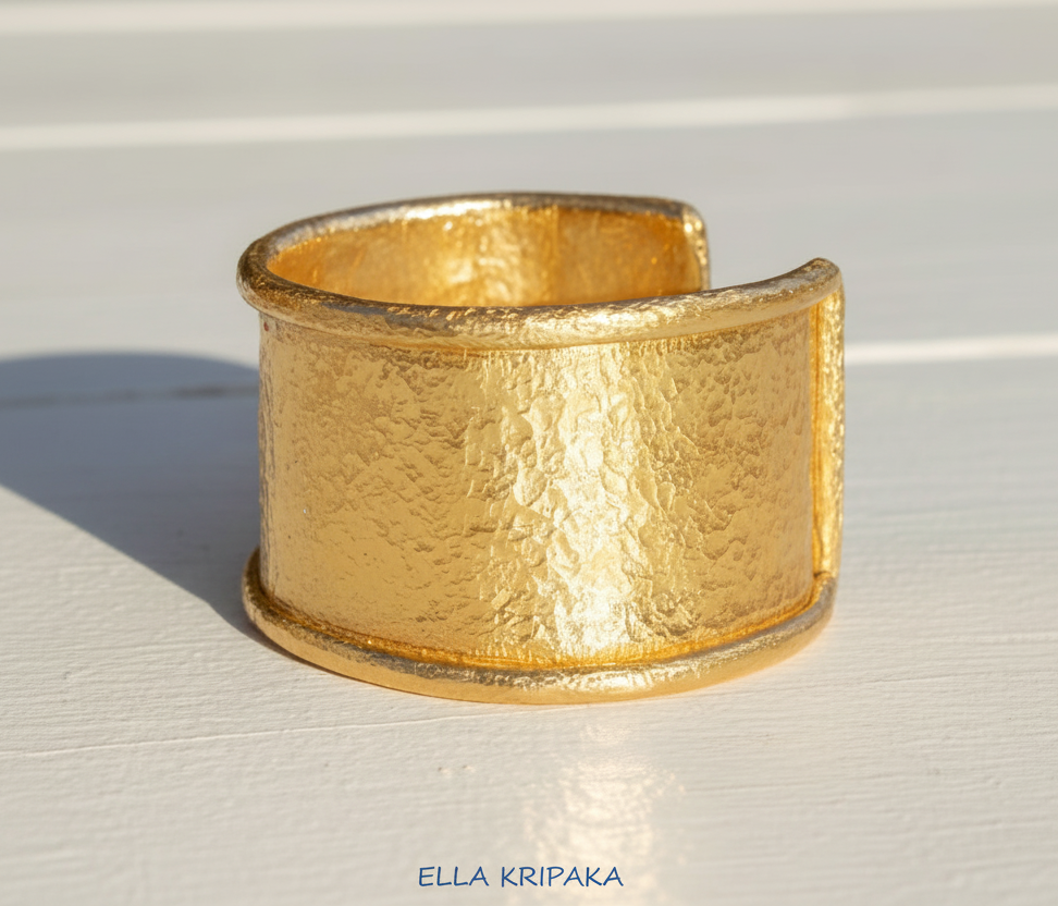 Hammered 24k 9999 gold bracelet large cuff Ancient Rome style with thick borders on a white background, branding artist-jeweler name 'Ella Kripaka'