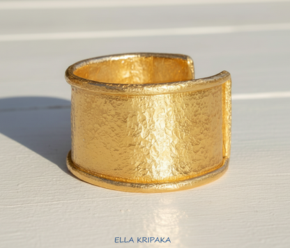 Hammered 24k 9999 gold bracelet large cuff Ancient Rome style with thick borders on a white background, branding artist-jeweler name 'Ella Kripaka'