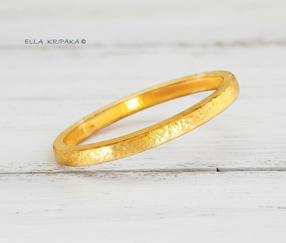 Hammered 24k gold 9999 gold bangle thick bracelet Ancient Rome style with light wooden background, forged 24k gold jewelry, artist-jeweler 'Ella Kripaka'