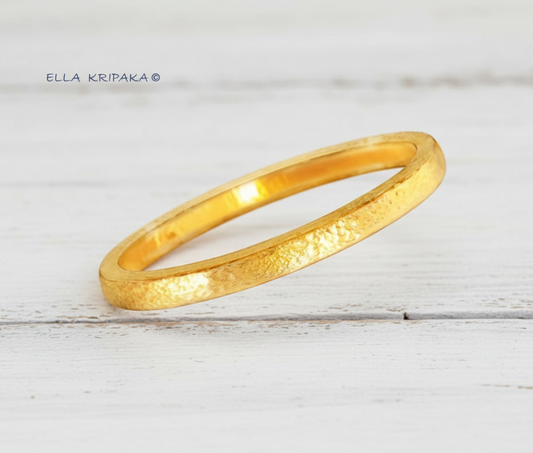 Hammered 24k gold 9999 gold bangle thick bracelet Ancient Rome style with light wooden background, forged 24k gold jewelry, artist-jeweler 'Ella Kripaka'