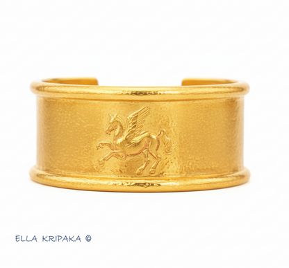 24k 9999 gold hammered Ancient Rome bracelet cuff with convex Pegasus on white background, indicating it is a custom-made jewelry with creator's name 'Ella Kripaka'
