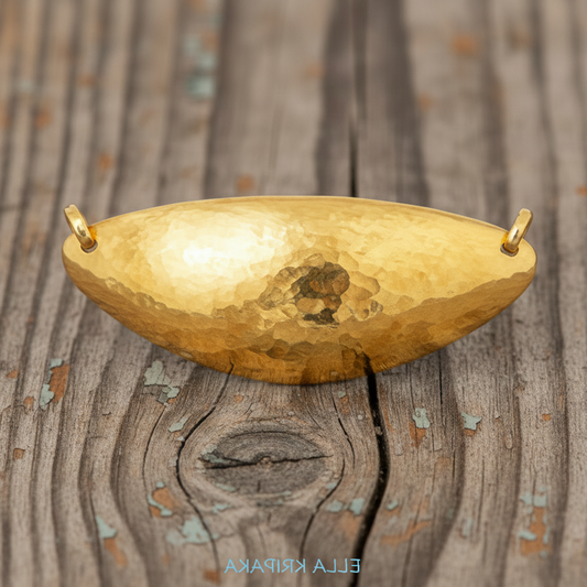 24k 9999 gold hammered dome pendant with forged gold textures is on a old wooden surface, artist's name 'Ella Kripaka'