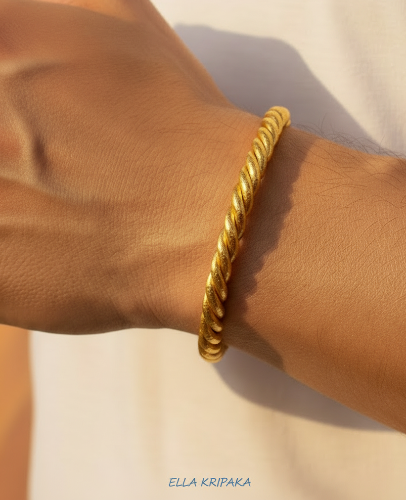 Viking 24k 9999 gold twisted cuff thick bracelet on a man's wrist with a neutral background, branding artist-jeweler name 'Ella Kripaka'