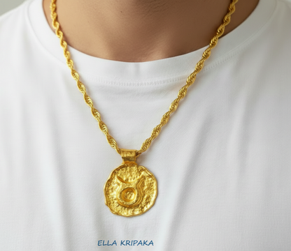 Hammered 24k 9999 gold Organic pendant with Taurus sign on chain wearing on man with white t-shirt background, branding artist name 'Ella Kripaka'