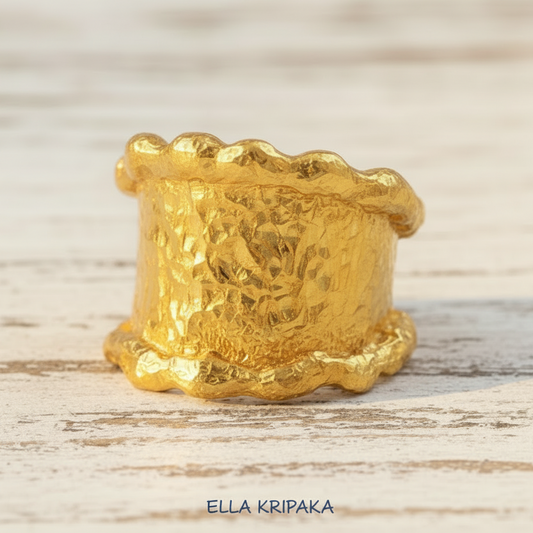 Organic hammered 24k 9999 Gold ring signet with uneven wavy thick edges on white old wooden surface, artist-jeweler's name 'Ella Kripaka' is written in picture