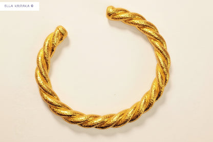 Twisted Viking Hammered 24k gold bracelet thick cuff on a white paper background, branding artist-jeweler name 'Ella Kripaka'