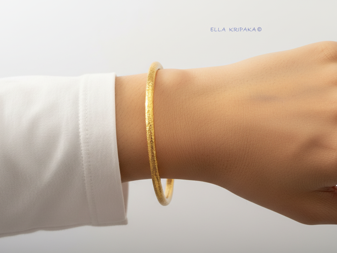 Hammered 24k 9999 gold bangle thick bracelet Ancient Rome style on person's wrist and on white background, artist-jeweler's name 'Ella Kripaka'