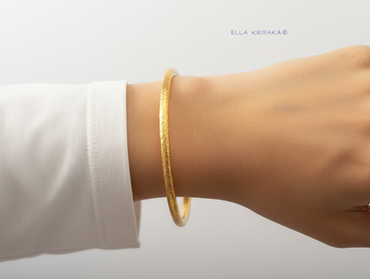 Hammered 24k 9999 gold bangle thick bracelet Ancient Rome style on person's wrist and on white background, artist-jeweler's name 'Ella Kripaka'