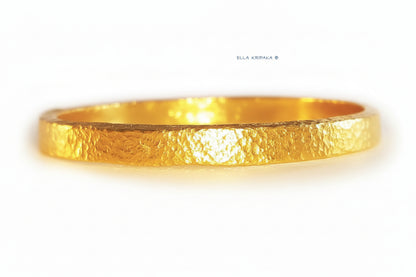 Hammered 24k 9999 gold bangle thick bracelet Ancient Rome style on a white background, artist-jeweler name 'Ella Kripaka' branding