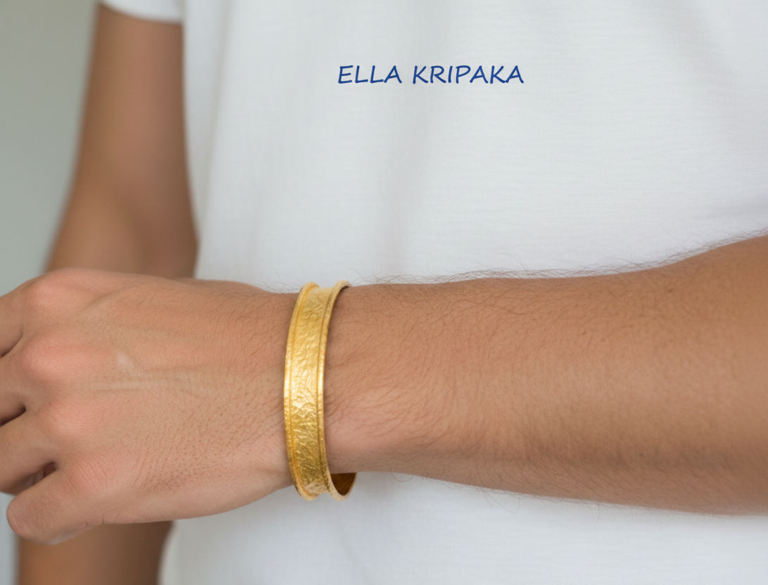 Hammered 24k 9999 Gold thick bangle bracelet Ancient Rome style worn by man on wrist and on white t-shirt background, artist's name 'Ella Kripaka' branding