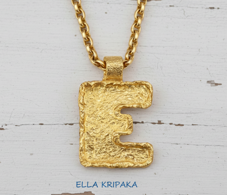 Gold necklace with hammeted organic 24k 9999 gold initial letter 'E' pendant on a white background, branded 'Ella Kripaka'