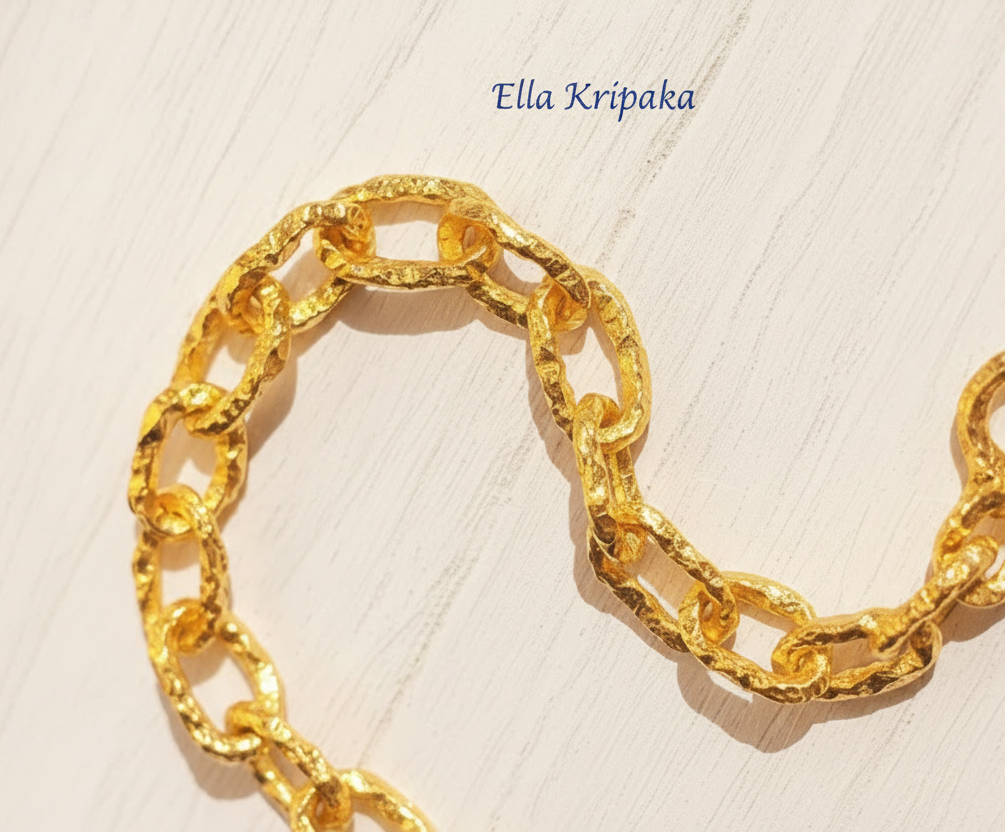 Hammered 24k 9999 gold organic necklace chain with hammered uneven textures and a thick hook clasp on white wooden surface, artist name 'Ella Kripaka'
