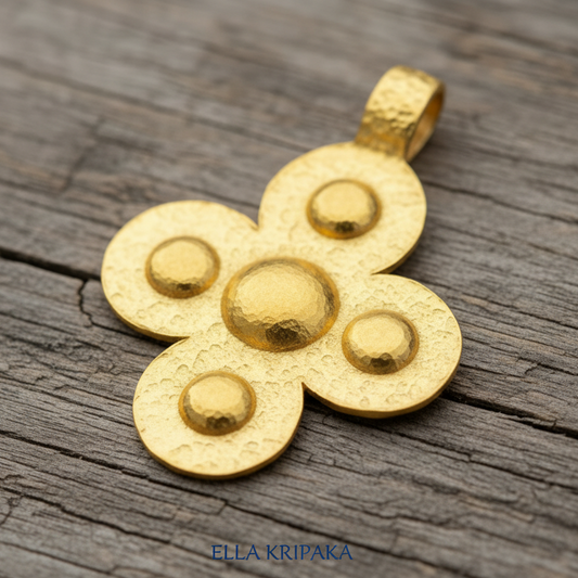 24k 9999 gold hammered Byzantine cross pendant with  forged gold textures is on a old wooden surface, artist's name 'Ella Kripaka'