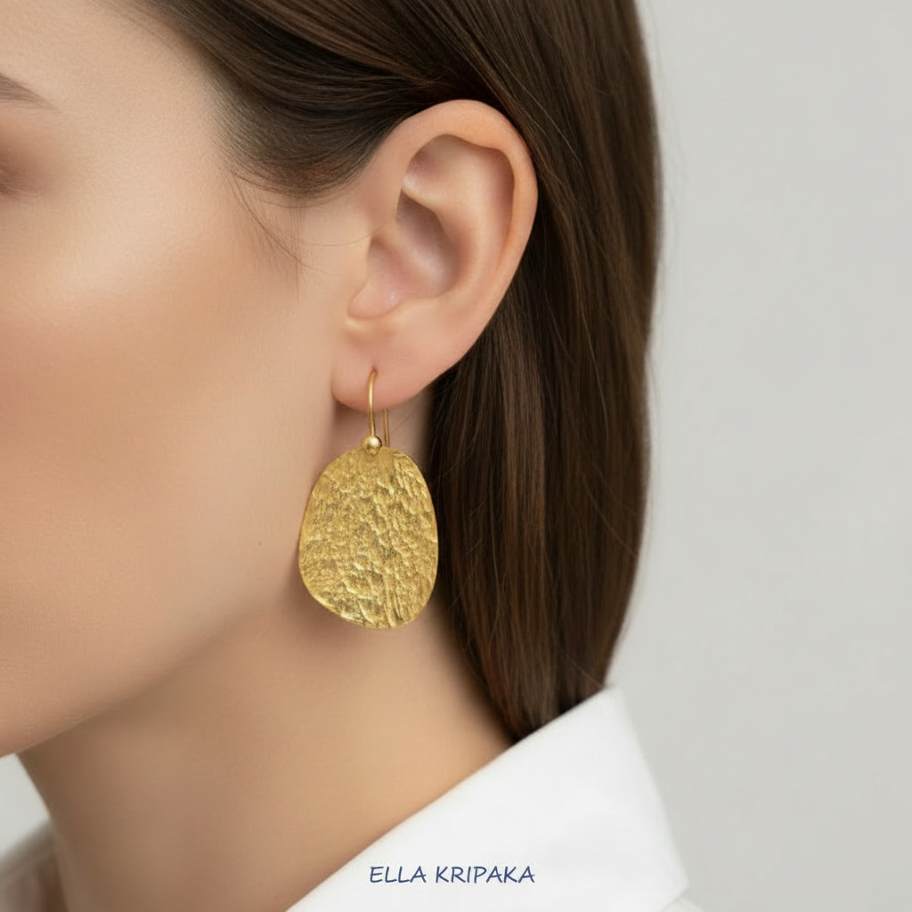 24k 9999 gold hammered organic earrings with forged gold textures wirn by a model, artist's name 'Ella Kripaka'