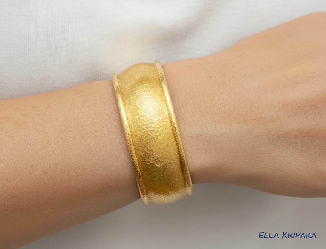 24k 9999 gold hammered convex cuff bracelet on a person's wrist a white background with 'Ella Kripaka' branding