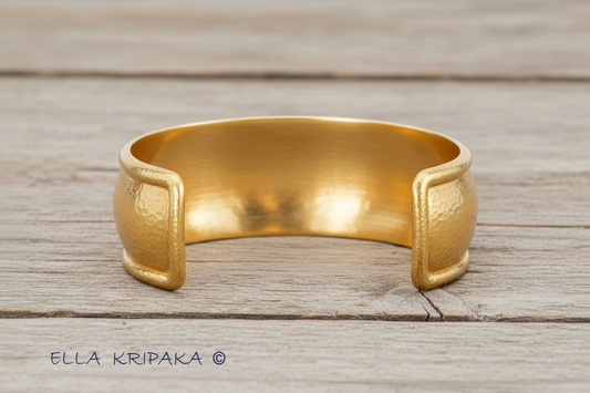 24k 9999 gold hammered Ancient Rome bracelet cuff on old wooden background, and with creator's name 'Ella Kripaka'