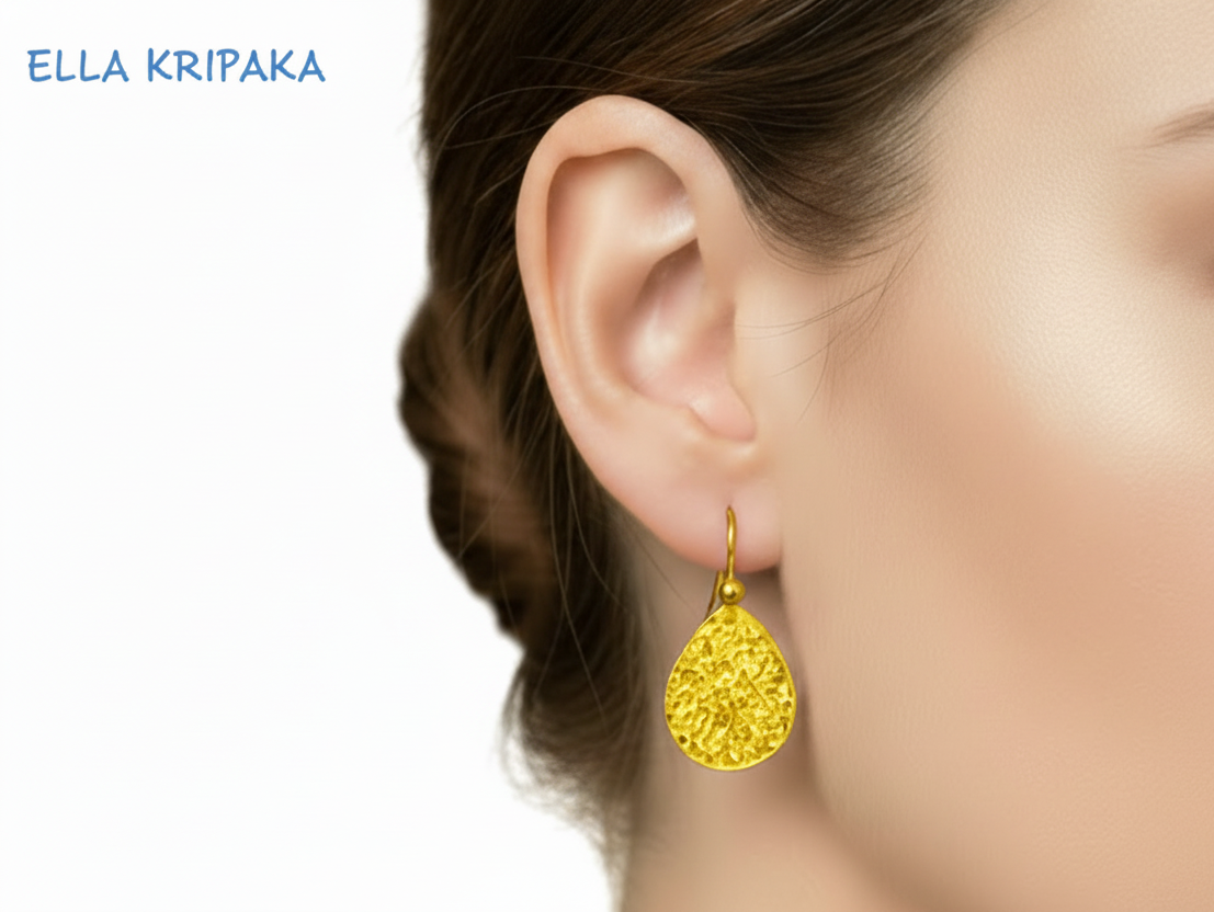 24k 9999 hammered drip gold earring worn by a person on a white background