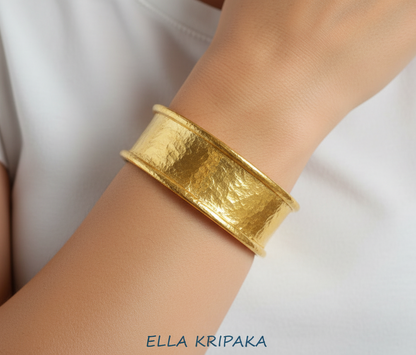 Hammered 24k 9999 gold bracelet cuff Ancient Rome style worn by a person and with a plain background, branding artist-jeweler name 'Ella Kripaka'