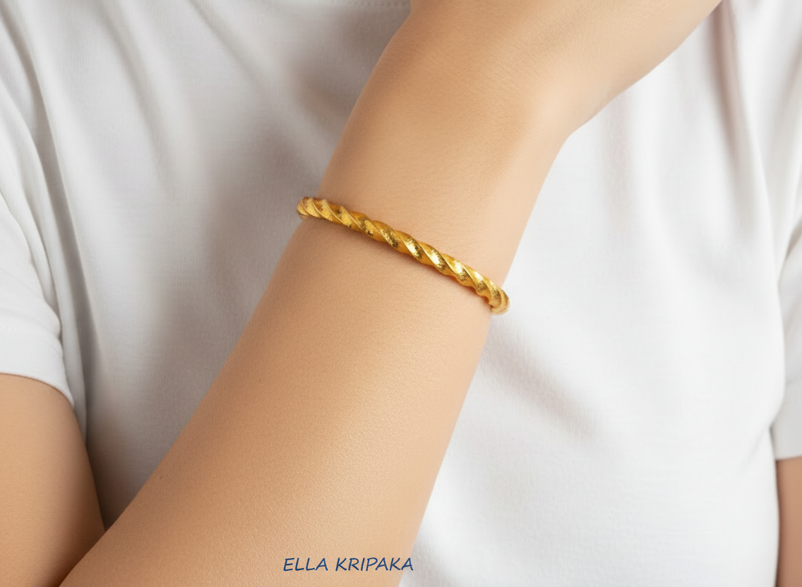 Twisted Viking Hammered 24k 9999 Gold bangle bracelet worn by a model on hand and on a white background, artist's name 'Ella Kripaka' branding