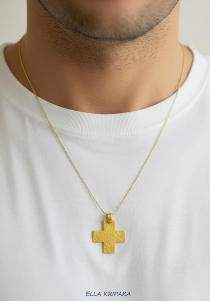Hammered 24k gold cross pendant with thin chain on a man wearing a white shirt, and with 'Ella Kripaka' branding