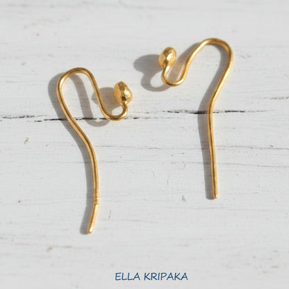22k gold earring hooks clasps on a white wooden surface with 'Ella Kripaka' branding