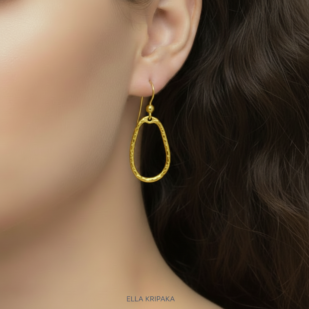 24 9999 Gold hammered organic hoop earring worn by a person with dark hair