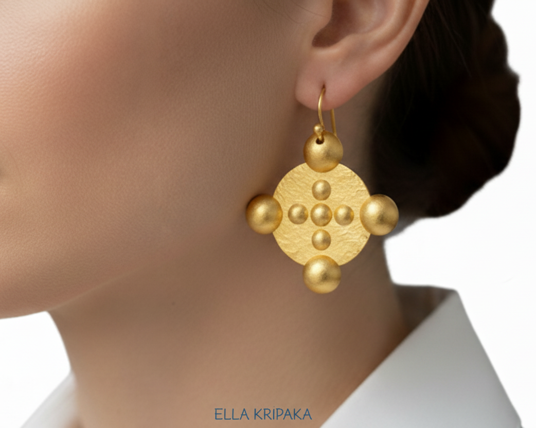 24k 9999 gold hammered Byzantine Cross earrings with forged gold textures is worn by person, artist's name 'Ella Kripaka'
