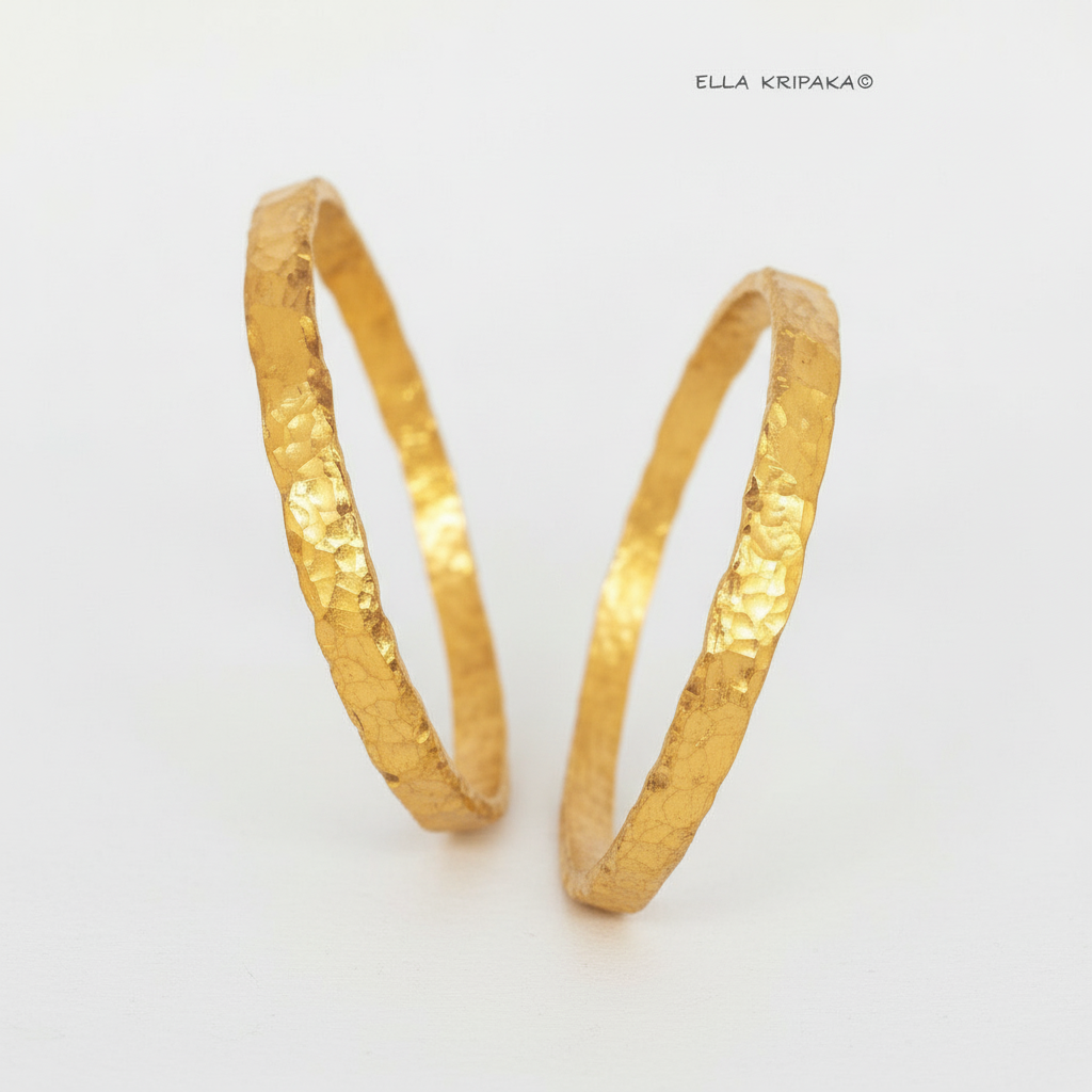 Organic hammered 24k 9999 Gold thick two bangles uneven bracelets on a white background, artist's name 'Ella Kripaka' branding