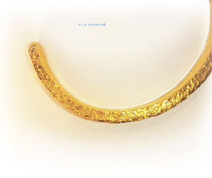 Hammered 24k 9999 gold cuff thick bracelet Ancient Rome style on a white background, artist-jeweler name 'Ella Kripaka' branding