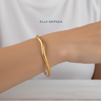 Organic 24k gold hammered textured bangle thick bracelet with uneven shape on woman's wrist, artist-jeweler 'Ella Kripaka'