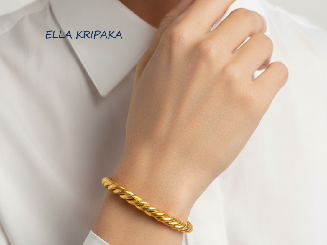 Viking twisted 24k 9999 Gold cuff bracelet on a person's wrist with a white shirt background, branding name 'Ella Kripaka'