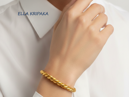 Viking twisted 24k 9999 Gold cuff bracelet on a person's wrist with a white shirt background, branding name 'Ella Kripaka'