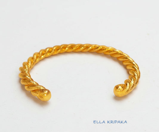 Twisted Viking Hammered 24k 9999 gold bracelet thick cuff on a white background, branding artist-jeweler name 'Ella Kripaka'