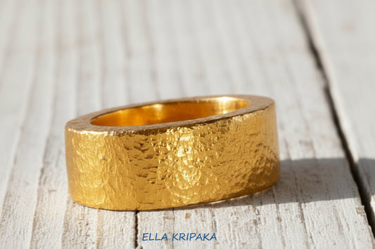 Hammered 24k Gold 9999 gold thick ring band Ancient Rome style with textured gold on old white wooden background, branded 'Ella Kripaka'